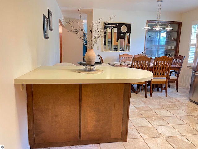 kitchen featuring a notable chandelier, light tile patterned floors, and pendant lighting