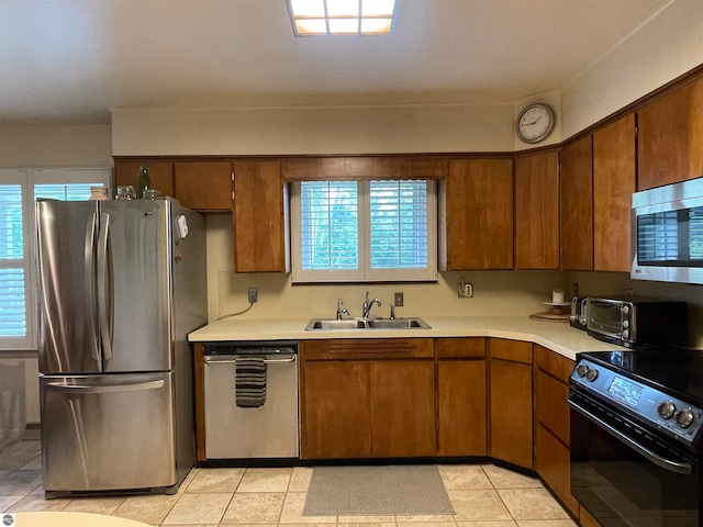 kitchen featuring light tile patterned floors, stainless steel appliances, and sink