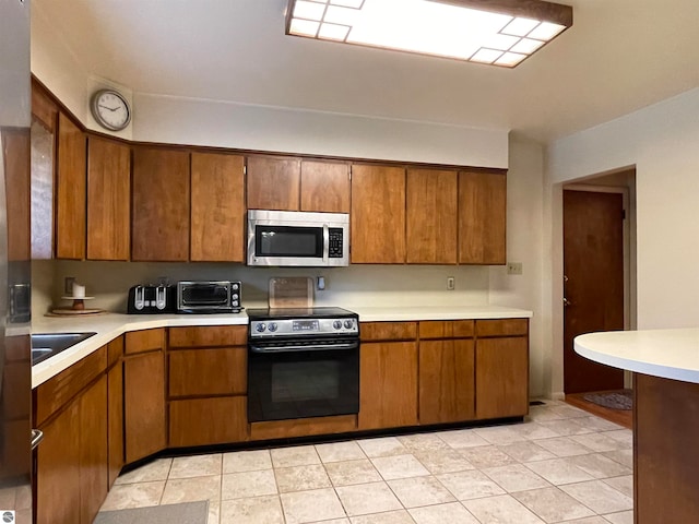 kitchen featuring light tile patterned flooring, sink, and black range with electric stovetop