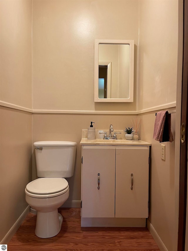 bathroom featuring vanity, toilet, and hardwood / wood-style floors