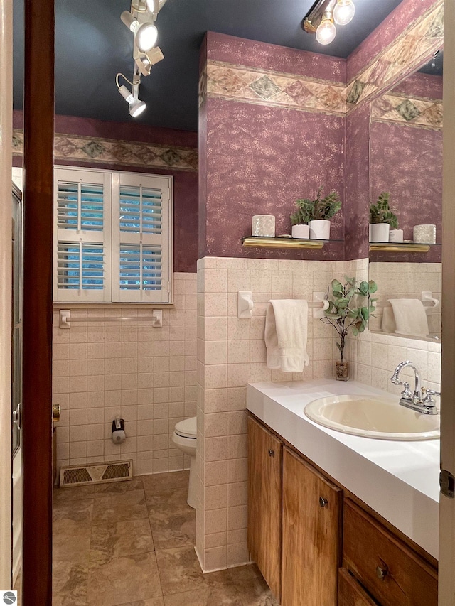 bathroom featuring tile walls, toilet, tile patterned floors, vanity, and backsplash