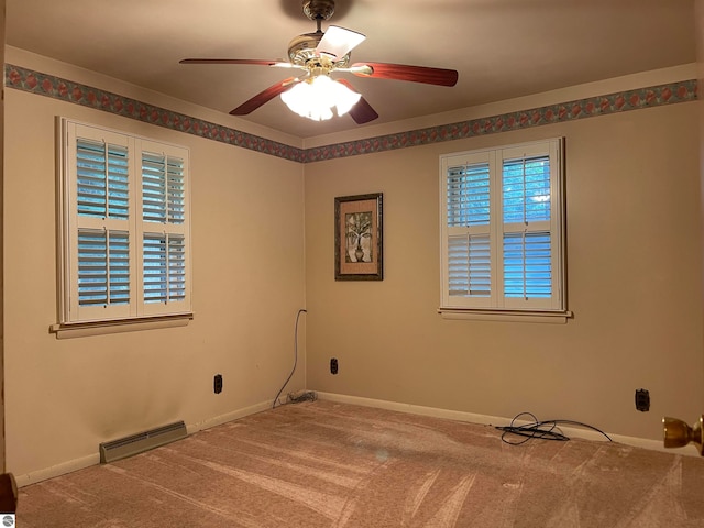 carpeted empty room featuring ceiling fan and a wealth of natural light