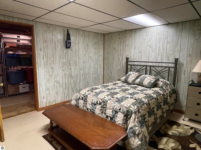 bedroom featuring wood walls, a paneled ceiling, and carpet floors