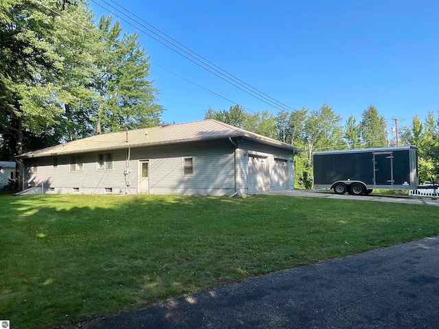 view of home's exterior with a garage and a lawn