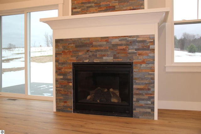 interior details featuring wood finished floors, a fireplace, and visible vents