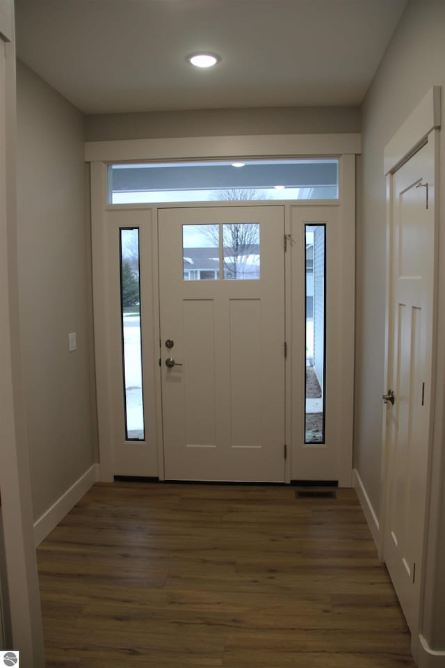 foyer with recessed lighting, baseboards, and wood finished floors