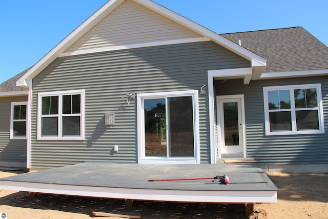 back of house with a deck and a shingled roof