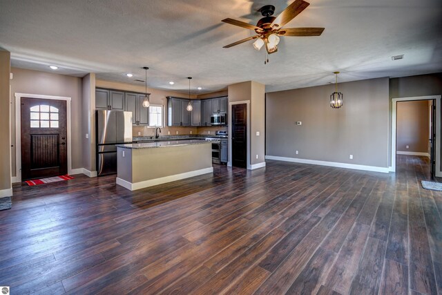 kitchen with appliances with stainless steel finishes, light stone counters, and gray cabinets