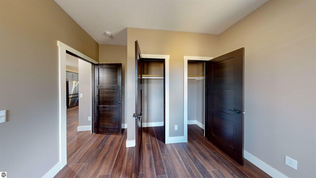 interior space featuring ceiling fan with notable chandelier and dark hardwood / wood-style flooring