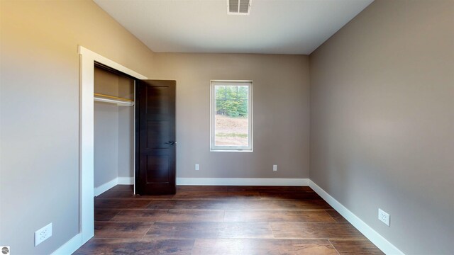 kitchen with dark wood-type flooring, stainless steel appliances, pendant lighting, gray cabinetry, and a center island