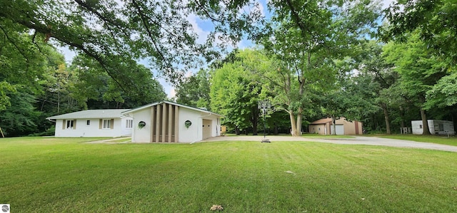 view of front of home with a front yard, a garage, and an outdoor structure