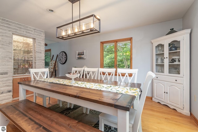 dining area featuring light wood-type flooring and an inviting chandelier