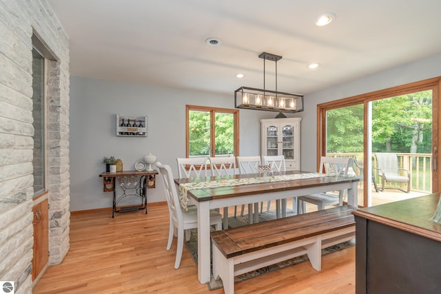 dining space with a notable chandelier and light hardwood / wood-style flooring