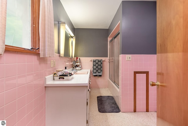 bathroom featuring tasteful backsplash, vanity, and tile walls