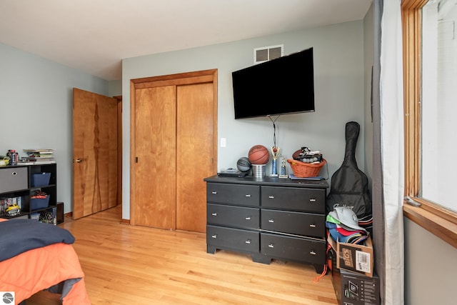 bedroom featuring light wood-type flooring and a closet