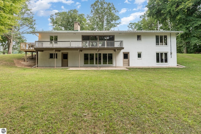 rear view of property featuring a deck and a lawn