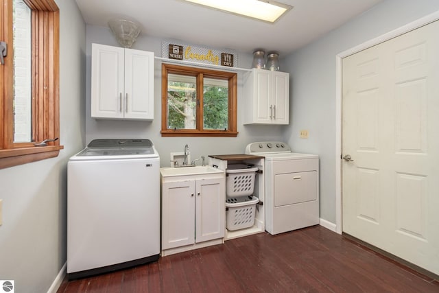 clothes washing area with cabinets, washing machine and dryer, dark hardwood / wood-style floors, and sink