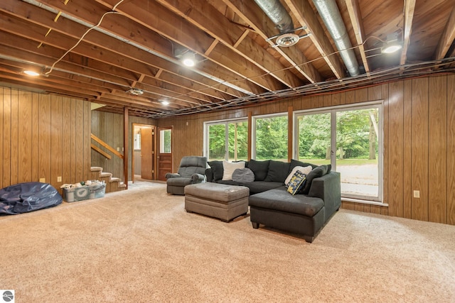 carpeted living room featuring wood walls and a healthy amount of sunlight