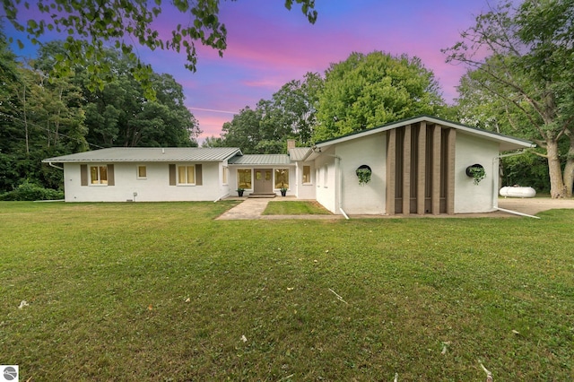 ranch-style home with a lawn