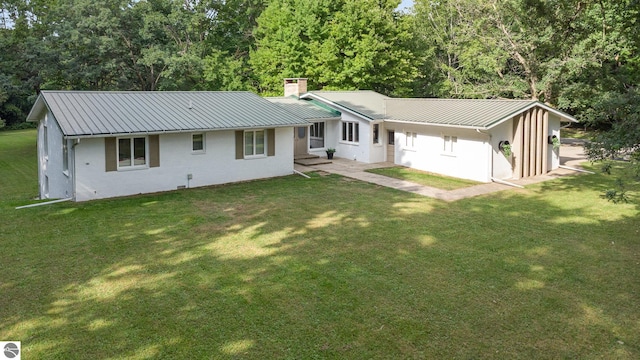 rear view of property featuring a lawn