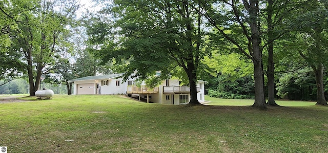 view of yard with a wooden deck and a garage