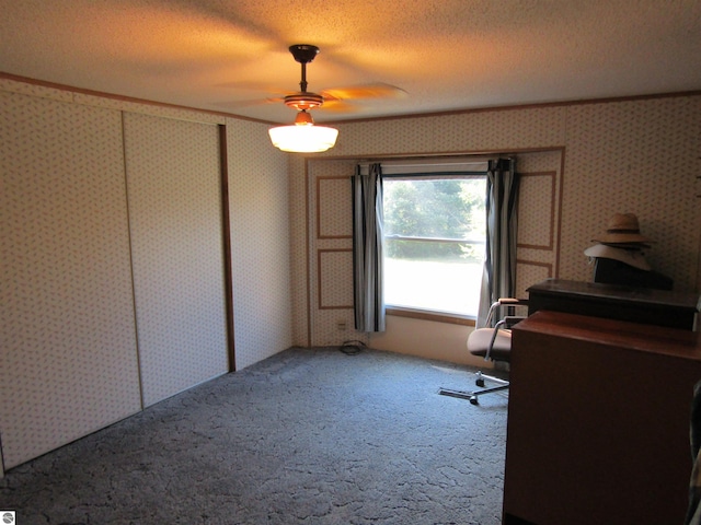 home office featuring carpet floors, ornamental molding, a textured ceiling, and wallpapered walls