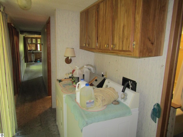 interior space featuring washer and dryer, cabinet space, and wallpapered walls