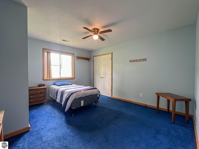 bedroom featuring a closet, ceiling fan, and dark colored carpet