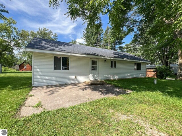 back of property with a lawn and a patio area