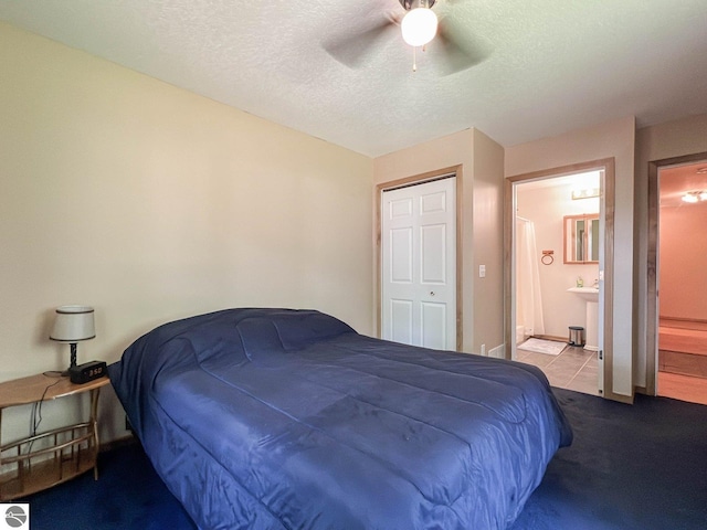 bedroom with ensuite bathroom, sink, a textured ceiling, ceiling fan, and light colored carpet