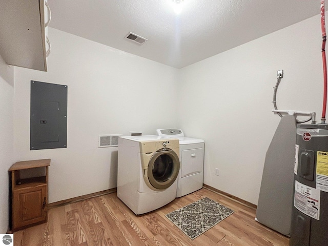 laundry area featuring washing machine and clothes dryer, electric panel, electric water heater, and light hardwood / wood-style flooring