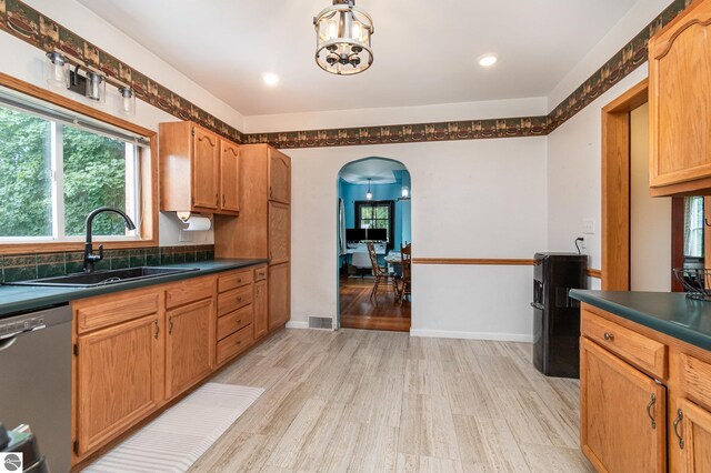 kitchen featuring a chandelier, sink, light hardwood / wood-style flooring, and dishwasher