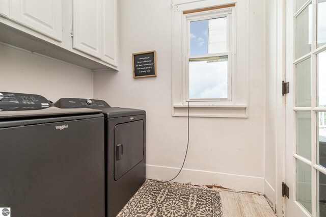 laundry room with independent washer and dryer, plenty of natural light, and cabinets