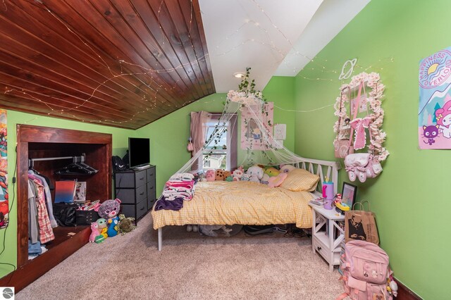 carpeted bedroom with a crib, lofted ceiling, and wood ceiling