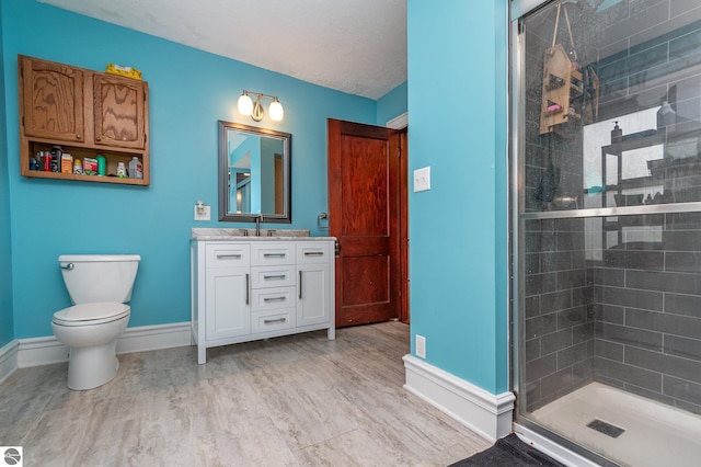 bathroom featuring vanity, wood-type flooring, a shower with door, and toilet