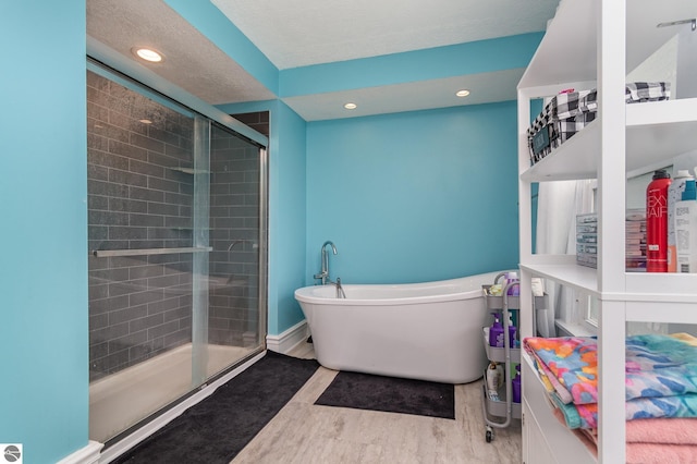 bathroom with hardwood / wood-style flooring and separate shower and tub