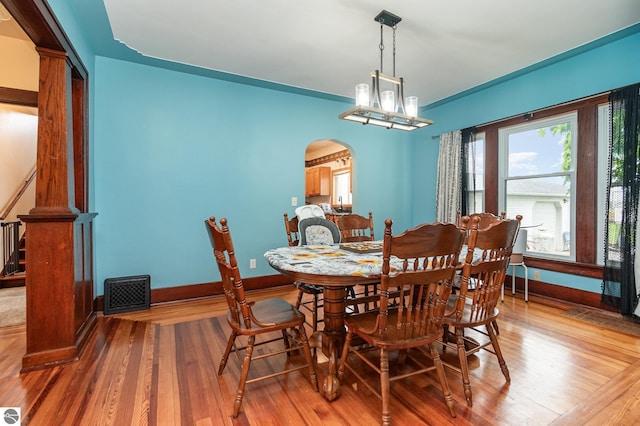 dining space with light hardwood / wood-style floors and a chandelier