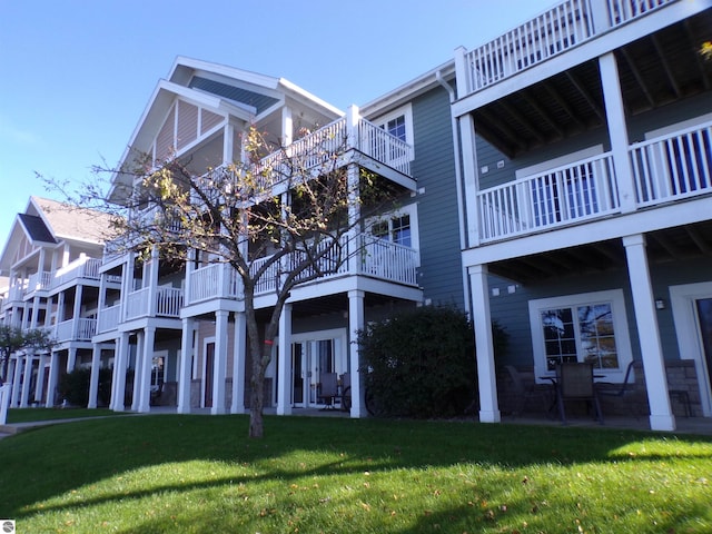 exterior space featuring a balcony and a lawn