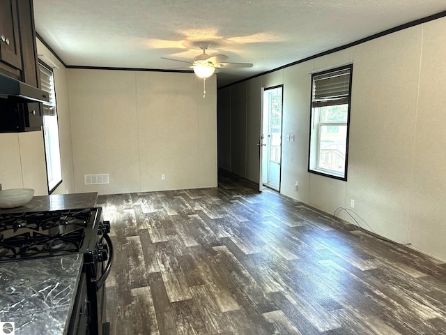 unfurnished living room featuring a textured ceiling, ornamental molding, wood finished floors, and visible vents