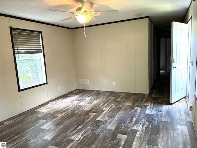 unfurnished room with a textured ceiling, wood finished floors, visible vents, a ceiling fan, and ornamental molding