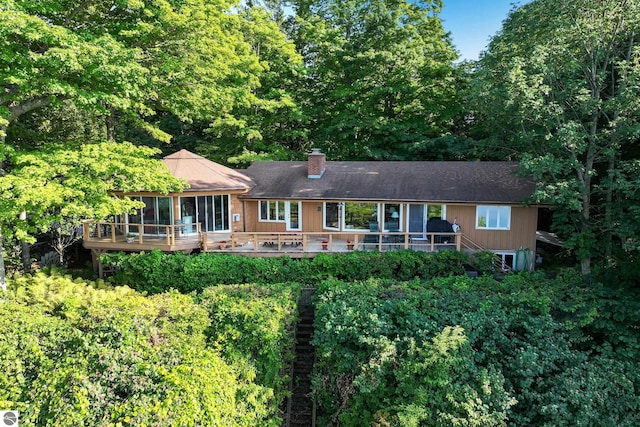 rear view of property with a deck and a sunroom