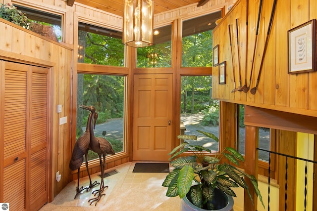 doorway to outside with wood walls