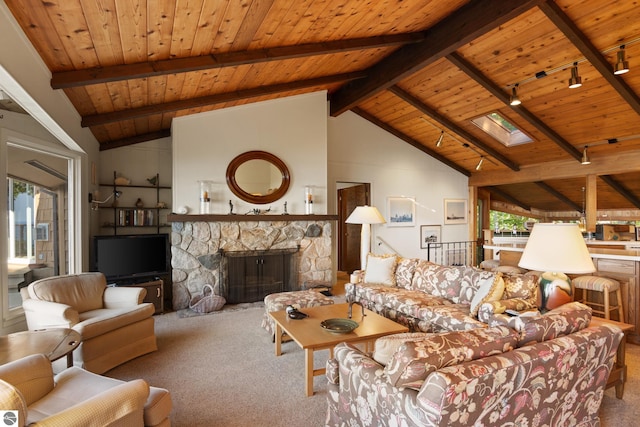 living room with carpet, beam ceiling, wood ceiling, a stone fireplace, and a skylight