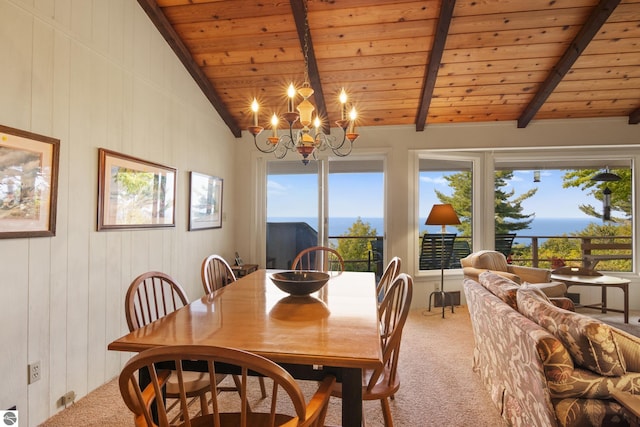 dining room featuring a notable chandelier, lofted ceiling with beams, a healthy amount of sunlight, wood ceiling, and light colored carpet