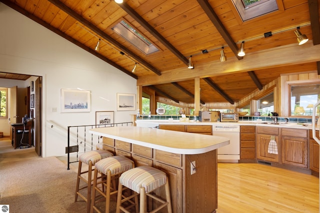 kitchen featuring track lighting, dishwasher, wood ceiling, and lofted ceiling with skylight