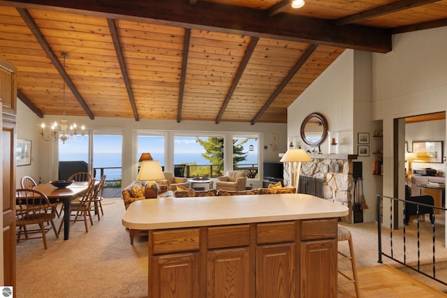 kitchen with a kitchen island, wooden ceiling, a stone fireplace, and pendant lighting