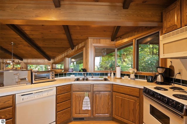 kitchen featuring white appliances, a healthy amount of sunlight, sink, and lofted ceiling with beams