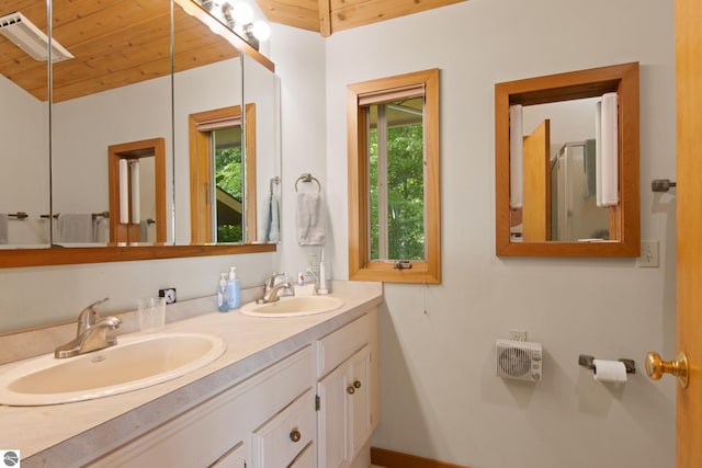 bathroom featuring a healthy amount of sunlight, wooden ceiling, and vanity