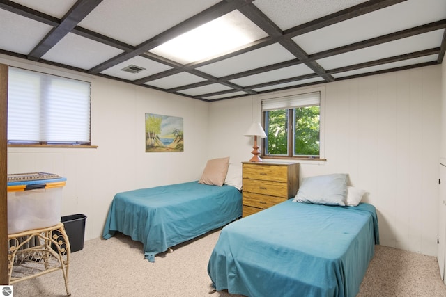 bedroom with coffered ceiling and carpet floors