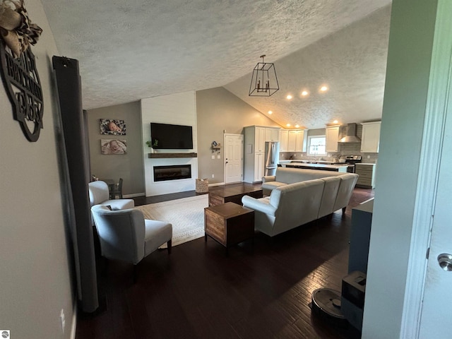 living room featuring a textured ceiling, vaulted ceiling, a large fireplace, and wood-type flooring